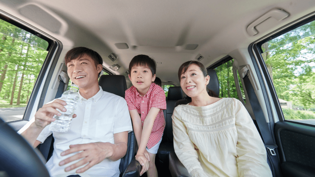 A family sitting in the back seat of a car