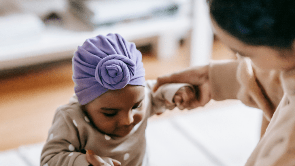 A person holding a baby while standing