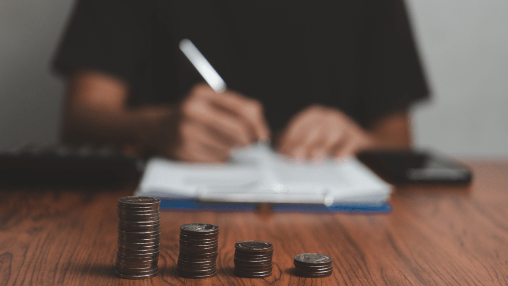 A person sitting at a desk with stacks of coins