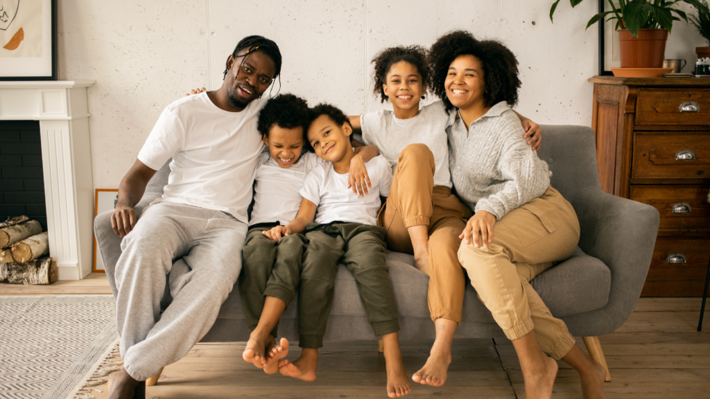 A family sitting on a couch reading a book