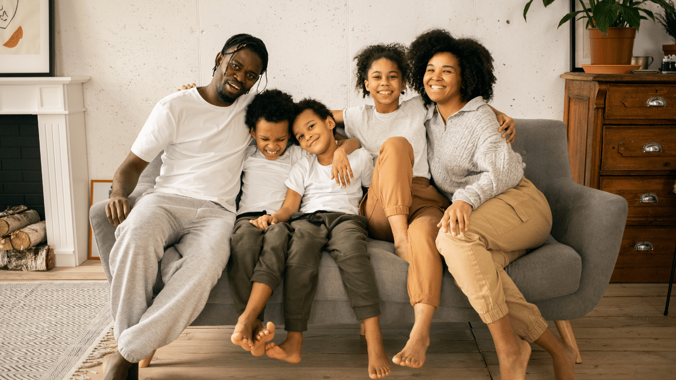 A family sitting on a couch reading a book