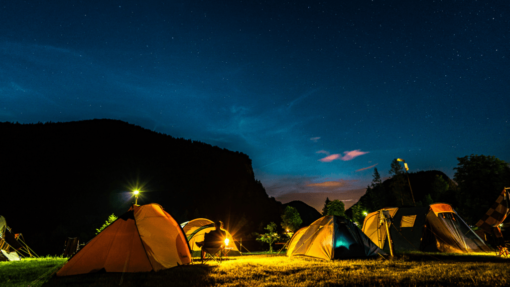 a group of tents set up in the woods at night