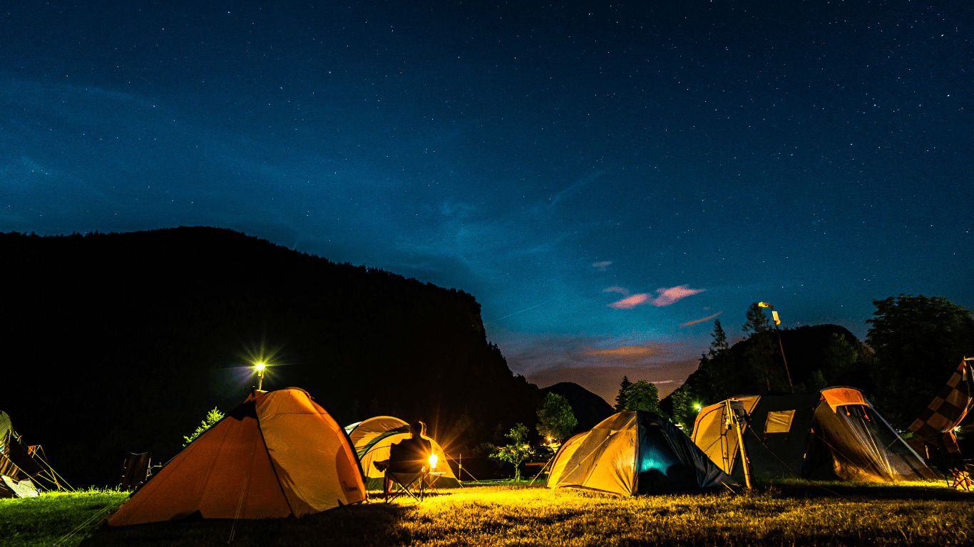 a group of tents set up in the woods at night