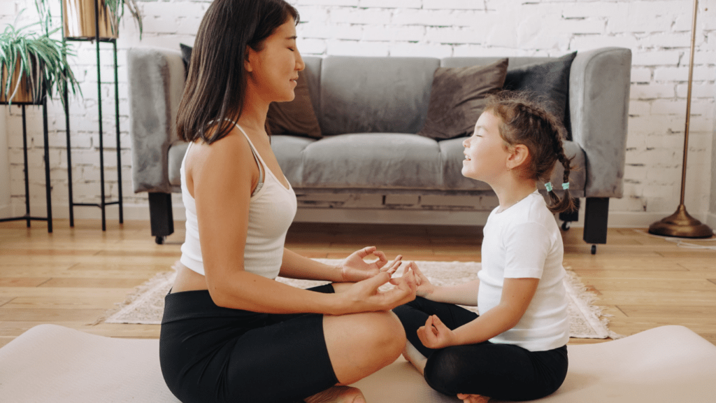 Mother and daughter doing yoga in the living room