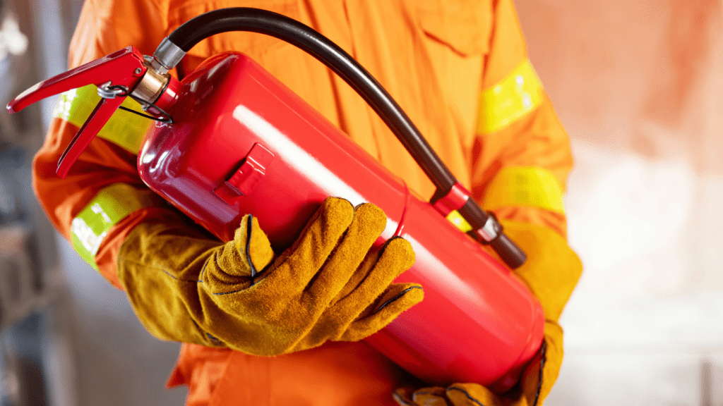 a person in an orange safety suit holding a fire extinguisher
