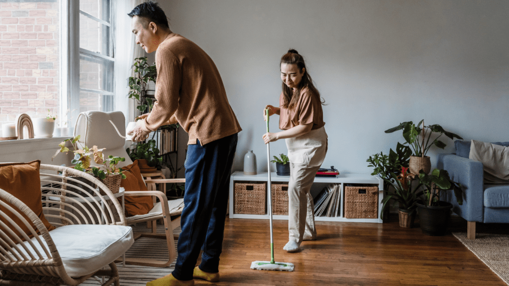 People cleaning hardwood floor in living room