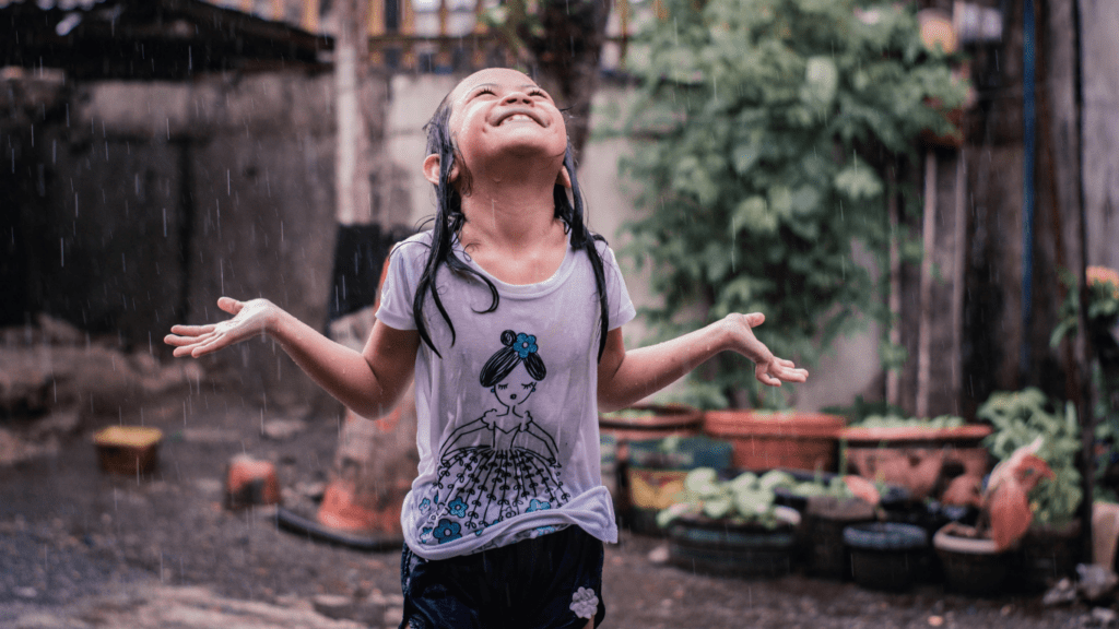 A child is playing in the rain