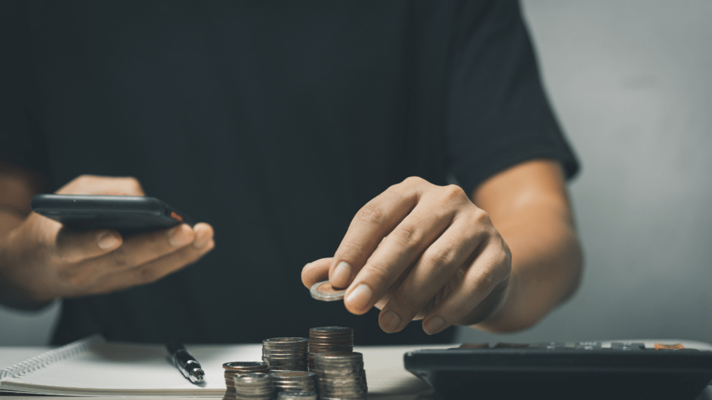 A person sitting at a desk with stacks of coins