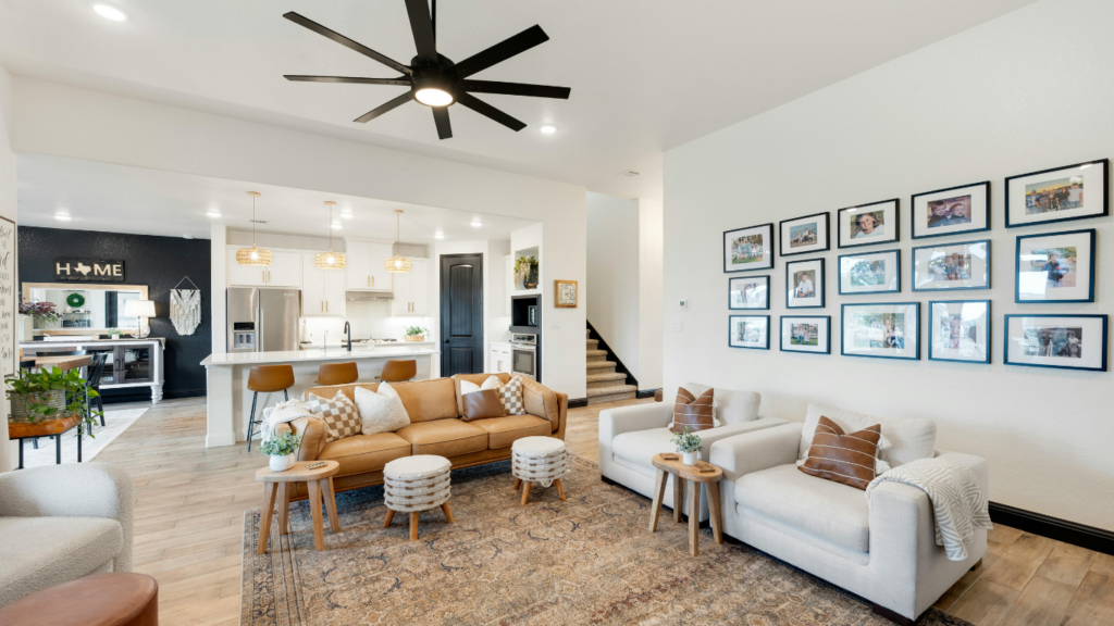 a living room with a ceiling fan and couches