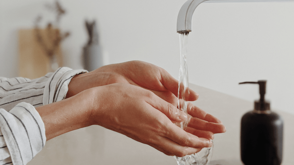 a person washing their hands in a sink